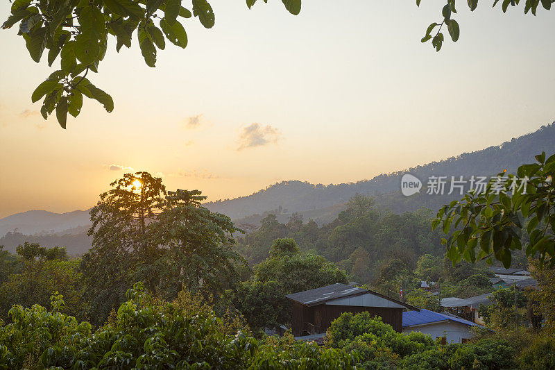 林地日落全景与小村庄在景观周围的山Phu Langka